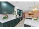 Bright kitchen showcasing quartz countertops, stainless steel appliances, green cabinetry, and modern lighting at 1558 Cottonwood Ter, Dunedin, FL 34698