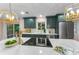 Modern kitchen featuring stainless steel appliances, quartz countertops, and stylish green cabinets at 1558 Cottonwood Ter, Dunedin, FL 34698