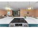 View of large kitchen island with cooktop, and open floor plan to living room beyond at 1558 Cottonwood Ter, Dunedin, FL 34698