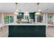 Kitchen with custom island, elegant pendant lighting, and stainless steel appliances at 1558 Cottonwood Ter, Dunedin, FL 34698