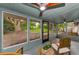 The screened porch features a ceiling fan and view of the large backyard at 1558 Cottonwood Ter, Dunedin, FL 34698