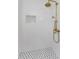 Detailed view of the shower showcasing the white tile and decorative tile shelf at 1558 Cottonwood Ter, Dunedin, FL 34698