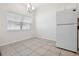 Bright dining area with tile floors, a modern chandelier and a window allowing for natural light to fill the space at 16314 Parkstone Palms Ct, Tampa, FL 33647