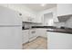 Well-lit kitchen featuring white cabinets, a white refrigerator and light-colored tile flooring at 16314 Parkstone Palms Ct, Tampa, FL 33647
