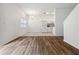 Spacious living room with wood-look floors adjacent to dining area and kitchen featuring tile floors at 16314 Parkstone Palms Ct, Tampa, FL 33647