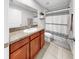 Bathroom features granite countertop, wood cabinets, and shower with striped curtain at 17136 Sunshine Mimosa: St, Wimauma, FL 33598