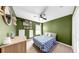 Cozy bedroom features a ceiling fan, decor shelves with books, and a bed for restful sleep at 17136 Sunshine Mimosa: St, Wimauma, FL 33598