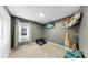 Cozy bedroom with mounted TV, plush giraffe, and window view at 17136 Sunshine Mimosa: St, Wimauma, FL 33598