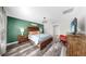 Main bedroom boasts wood floors, accent wall, and stylish lighting fixture at 17136 Sunshine Mimosa: St, Wimauma, FL 33598