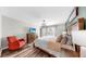 Spacious main bedroom with hardwood floors, accent wall, and cozy rocking chair at 17136 Sunshine Mimosa: St, Wimauma, FL 33598