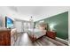 Bright main bedroom with hardwood floors, accent wall, and dresser with TV at 17136 Sunshine Mimosa: St, Wimauma, FL 33598