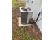 This is a gray AC unit attached to the side of a house with black insulated piping at 1807 E Bougainvillea Ave, Tampa, FL 33612