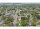 A high aerial captures a neighborhood lined with streets and green foliage, and distant city landmarks at 1807 E Bougainvillea Ave, Tampa, FL 33612