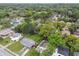The aerial view captures a neighborhood with houses surrounded by vibrant green trees at 1807 E Bougainvillea Ave, Tampa, FL 33612