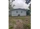 Rear exterior of a single-story home with gray siding and small backyard at 1807 E Bougainvillea Ave, Tampa, FL 33612
