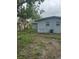 Backyard featuring a single-story home with gray siding and modest landscaping at 1807 E Bougainvillea Ave, Tampa, FL 33612