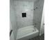 Bathroom showcasing a bathtub with white marble tiling and black tiled inset at 1807 E Bougainvillea Ave, Tampa, FL 33612