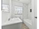 Bright bathroom featuring a modern vanity with white countertop and a tub-shower combo with marble-look tile surround at 1807 E Bougainvillea Ave, Tampa, FL 33612