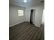A spacious bedroom with gray laminate wood floors and a bifold closet at 1807 E Bougainvillea Ave, Tampa, FL 33612