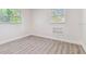 Bright bedroom featuring light wood-look floors, two windows, and a built-in shelving unit at 1807 E Bougainvillea Ave, Tampa, FL 33612