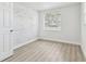 Comfortable bedroom featuring a painted brick wall accent, wood-look flooring, and natural light at 1807 E Bougainvillea Ave, Tampa, FL 33612