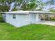 Exterior showcasing light blue paint, a well maintained yard, and a driveway at 1807 E Bougainvillea Ave, Tampa, FL 33612