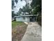 Charming single-story home with a covered parking and a quaint front yard on an overcast day at 1807 E Bougainvillea Ave, Tampa, FL 33612