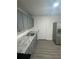 Modern gray kitchen with marble countertops, stainless steel sink, and light woodgrain flooring at 1807 E Bougainvillea Ave, Tampa, FL 33612