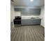 Modern kitchen featuring gray cabinets, marble countertops, stainless steel appliances and light woodgrain flooring at 1807 E Bougainvillea Ave, Tampa, FL 33612