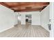 Bright living room with wood beam ceiling, freshly painted walls, and modern wood-look floors at 1807 E Bougainvillea Ave, Tampa, FL 33612