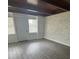 Bright living room with hardwood floors, a wooden beam ceiling, and a decorative painted brick wall at 1807 E Bougainvillea Ave, Tampa, FL 33612