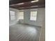 Bright living room with hardwood floors, a wooden beam ceiling, and a decorative painted brick wall at 1807 E Bougainvillea Ave, Tampa, FL 33612