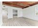 Spacious living room showcasing wood beam ceiling, light wood floors, and views into kitchen at 1807 E Bougainvillea Ave, Tampa, FL 33612