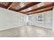Bright living room with wood beam ceiling, freshly painted walls, and modern wood-look floors at 1807 E Bougainvillea Ave, Tampa, FL 33612