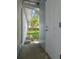 Side yard exterior showcasing a white door, side of house, concrete walkway, and greenery at 1807 E Bougainvillea Ave, Tampa, FL 33612