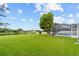 Expansive backyard featuring well-manicured lawn and screened-in pool area at 18219 Bittern Ave, Lutz, FL 33558