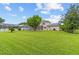 Large backyard with lush green grass and a screen-enclosed pool at 18219 Bittern Ave, Lutz, FL 33558