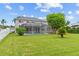 Spacious backyard featuring a screened-in pool, a well-manicured lawn, and lush landscaping at 18219 Bittern Ave, Lutz, FL 33558