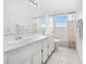 Bathroom with dual sinks, white cabinetry, a large mirror, and a shower with a tub at 18219 Bittern Ave, Lutz, FL 33558