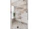 Tiled stand-up shower with pebbled flooring and glass door at 18219 Bittern Ave, Lutz, FL 33558