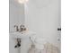 A well-lit half-bathroom featuring a pedestal sink, a toilet, and tile flooring at 18219 Bittern Ave, Lutz, FL 33558