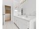 Bright bathroom with double sinks, white cabinets, and a large mirror for a spacious feel at 18219 Bittern Ave, Lutz, FL 33558