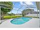Inviting screened-in pool with sparkling blue water, complemented by a serene backyard and picturesque waterfront view at 18219 Bittern Ave, Lutz, FL 33558