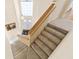 Carpeted staircase with wooden railing leading to the front door with transom window at 18219 Bittern Ave, Lutz, FL 33558