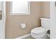 Bathroom featuring a white toilet, neutral walls, and a window for natural light at 18219 Bittern Ave, Lutz, FL 33558