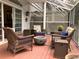 Cozy back porch featuring comfortable wicker chairs around a modern fire pit under a screened enclosure at 2015 Vista Del Sol # 108, Lutz, FL 33558