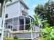 Back of the property with a screened in back porch, and view of lush greenery at 2015 Vista Del Sol # 108, Lutz, FL 33558