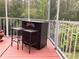 View of an outdoor bar with stools on a screened-in back porch, perfect for entertaining guests at 2015 Vista Del Sol # 108, Lutz, FL 33558
