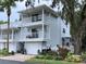 Two-story condo with dual balconies, a garage, lush landscaping and brick paver driveway at 2015 Vista Del Sol # 108, Lutz, FL 33558