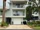 Two-story condo with dual balconies, a garage, lush landscaping and brick paver driveway at 2015 Vista Del Sol # 108, Lutz, FL 33558